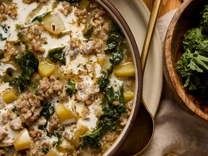 Hearty Zuppa Toscana soup with kale, potatoes, sausage, and cream served in a bowl, perfect for comforting meals.