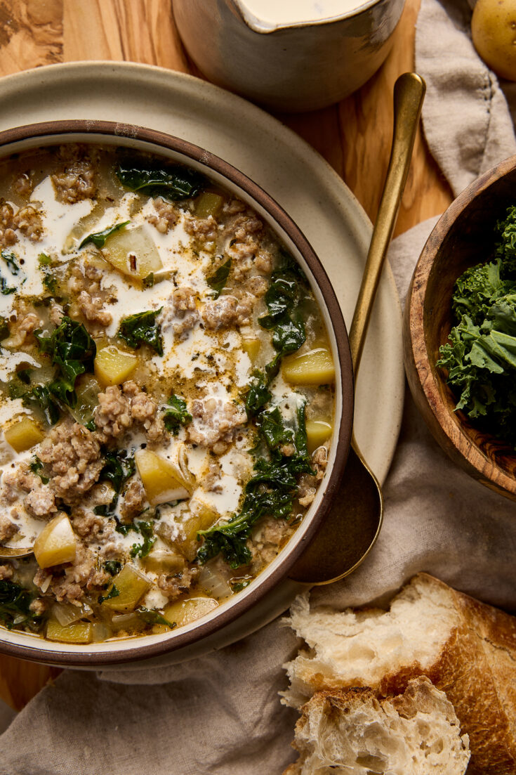 Hearty Zuppa Toscana soup with kale, potatoes, sausage, and cream served in a bowl, perfect for comforting meals.