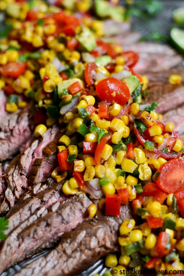 Juicy grilled steak topped with fresh corn salsa and colorful vegetables, perfect for summer meals and outdoor gatherings. A flavorful and visually appealing dish for steak lovers.