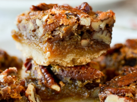 Rich, gooey pecan pie bars with a buttery crust and caramel topping, perfect for holiday dessert recipes and sweet treats.