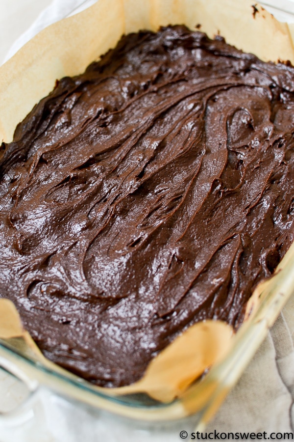 Decadent homemade fudge brownie batter fresh from the oven, coated with rich chocolate frosting, perfect for dessert lovers looking for sweet treats.