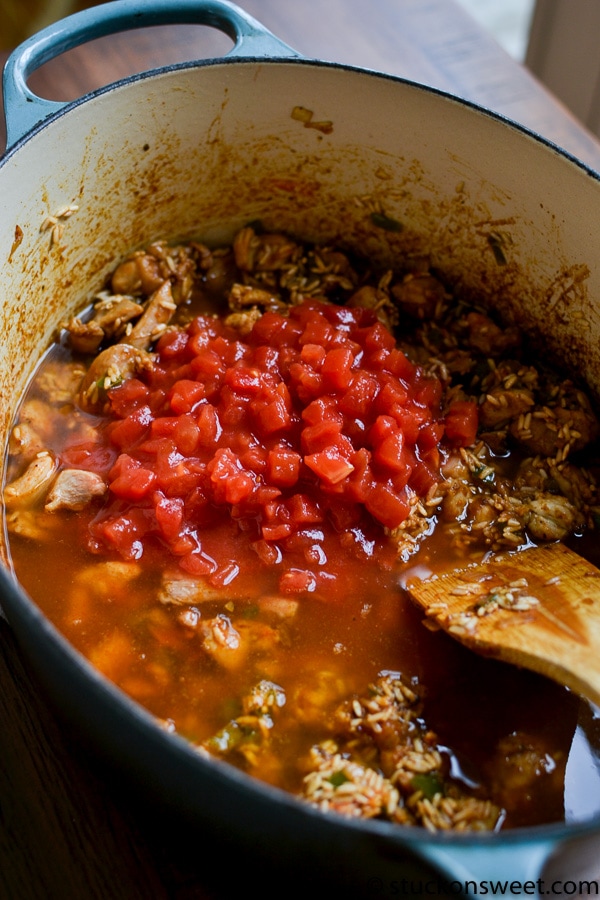 Freshly cooked chili simmering in a cast iron skillet with diced tomatoes and rice, showcasing delicious comfort food perfect for cozy dinners.