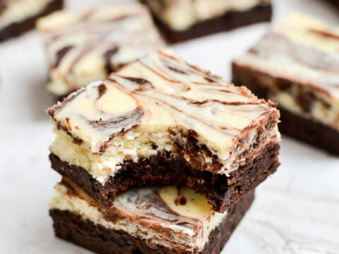 Decadent marble brownies with creamy vanilla and rich chocolate swirled topping, perfect for dessert lovers and sweet tooth cravings.