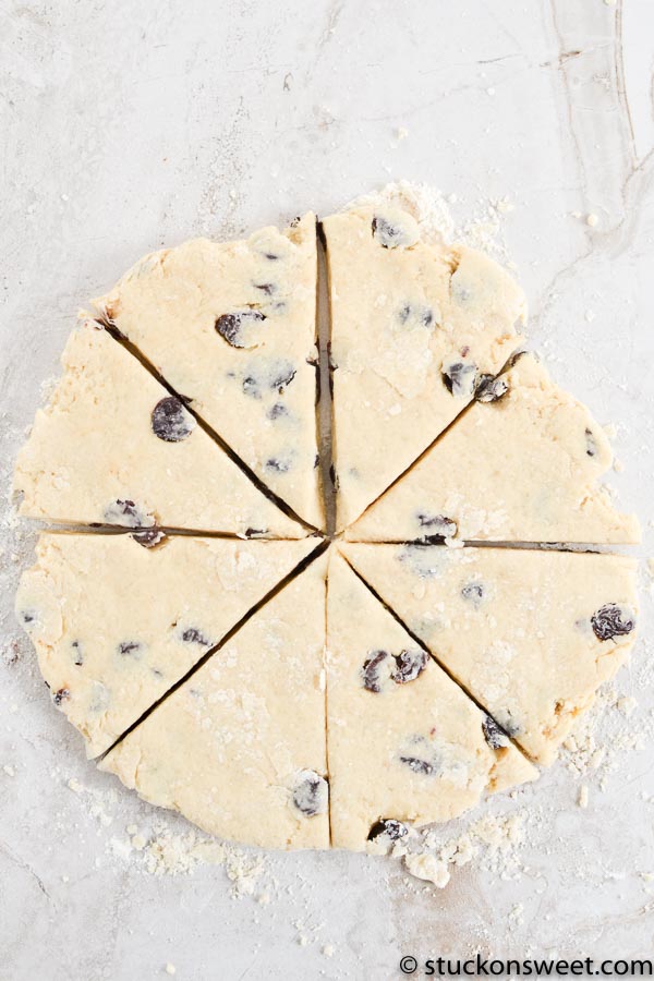 Creamy chocolate chip cookie dough ready to be baked, sliced into pieces on a floured surface. Perfect for homemade cookie recipes, desserts, and sweet treats.