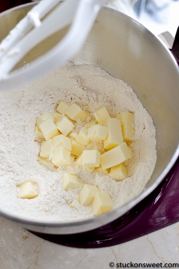 Butter and flour being mixed in a stand mixer for baking or cooking purposes.