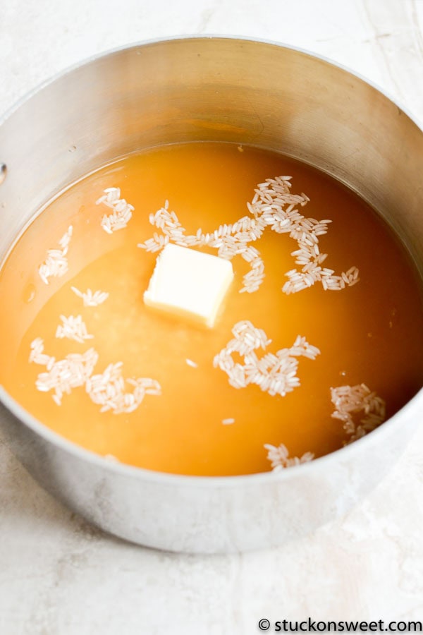 Melting butter and rice in a saucepan for sweet rice pudding or dessert recipe.
