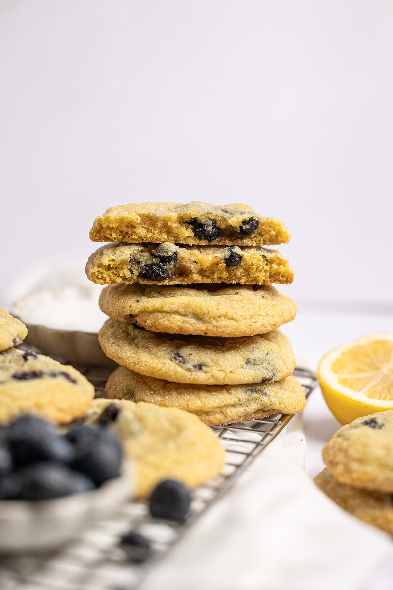Buttery chocolate chip cookies stacked with fresh lemon slices on a cooling rack, showcasing classic and delicious homemade cookie recipes from Stuck On Sweet.