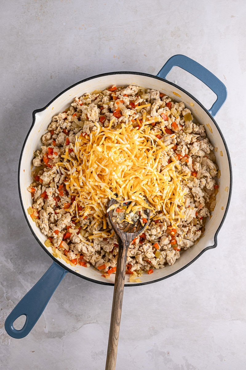 Ground turkey, vegetable, and cheese skillet dish with shredded cheddar cheese on top.
