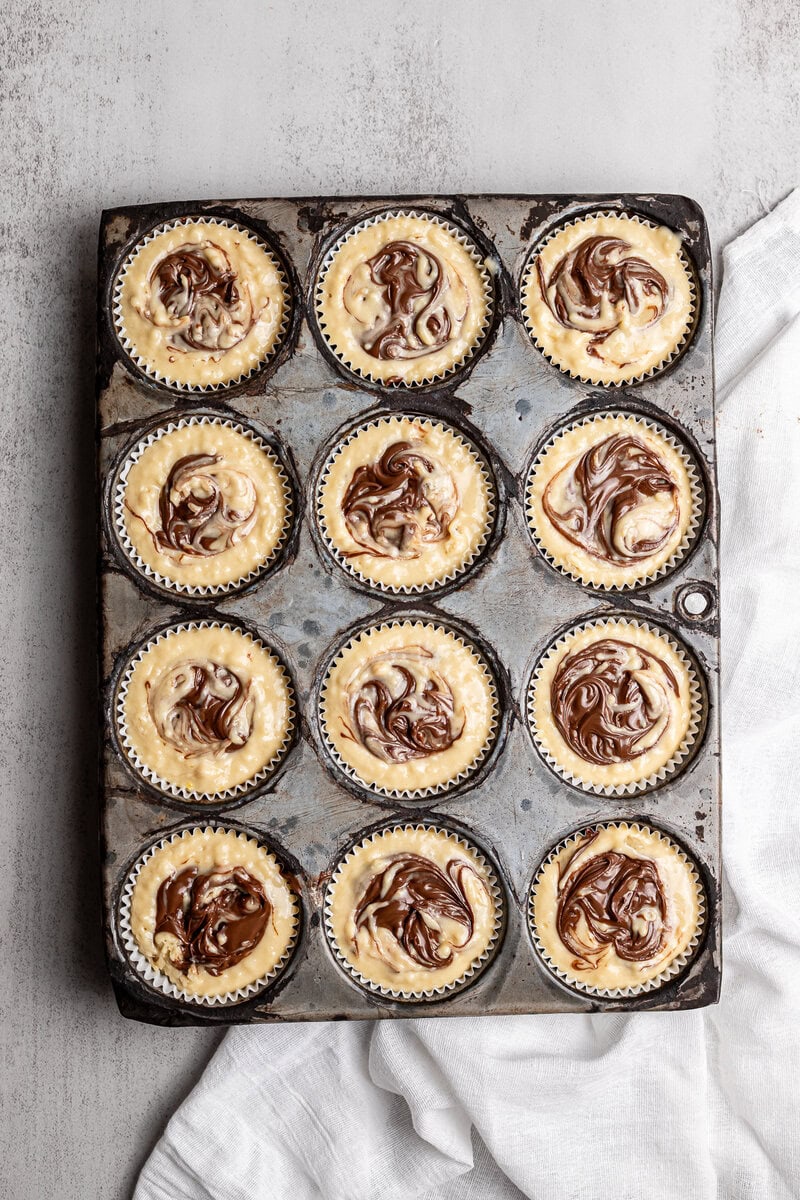 Cream cheese and chocolate swirl cupcake mini muffins on baking tray.