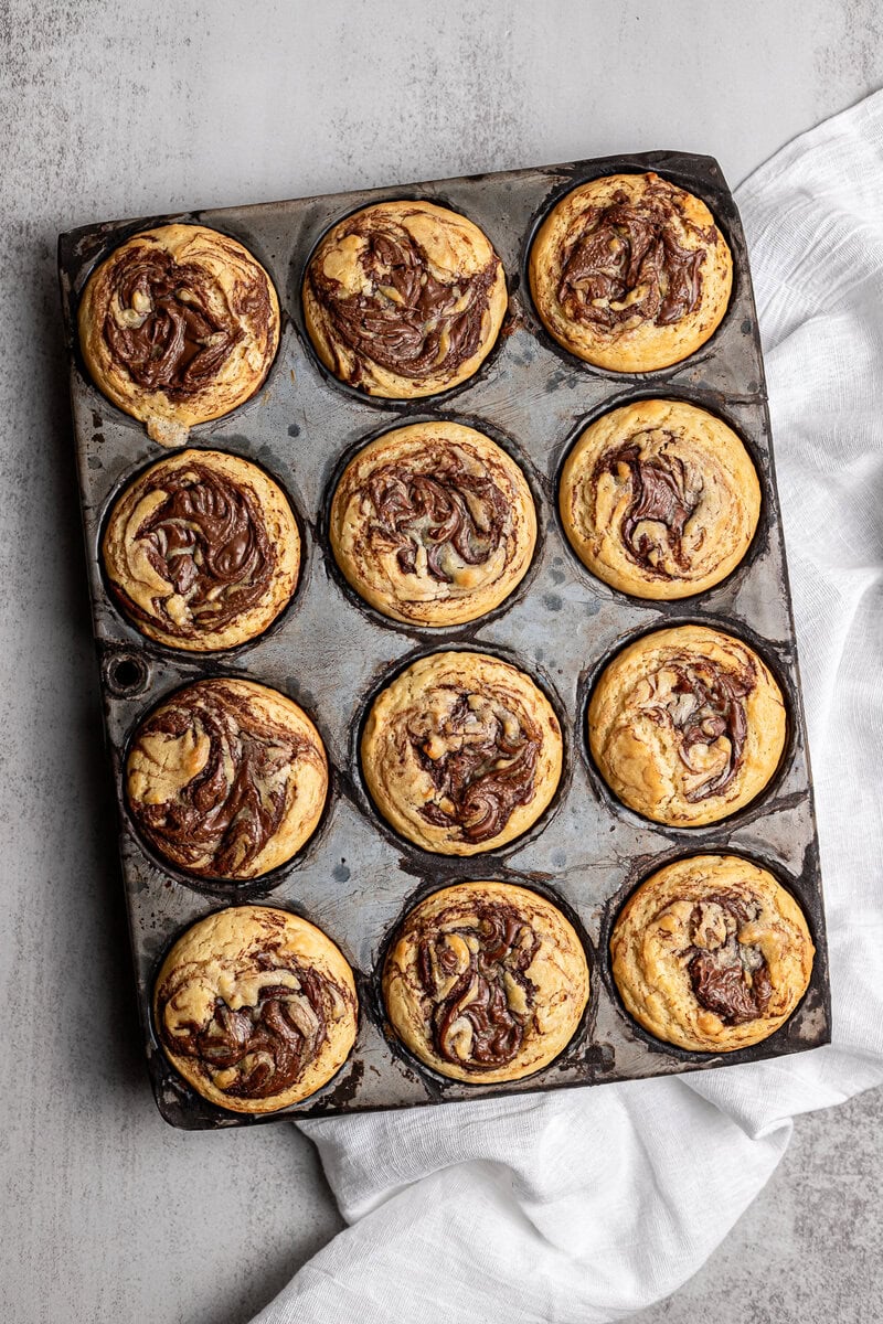 Rich chocolate swirl cookie dough cupcakes on a baking sheet.