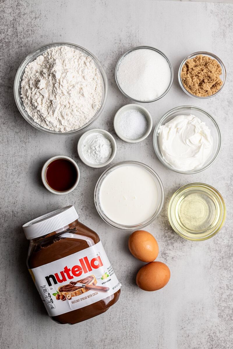 Creamy Nutella, eggs, flour, sugar, vanilla, and baking ingredients for delicious homemade desserts. Perfect for baking Nutella-flavored treats, cookies, and cakes at home.
