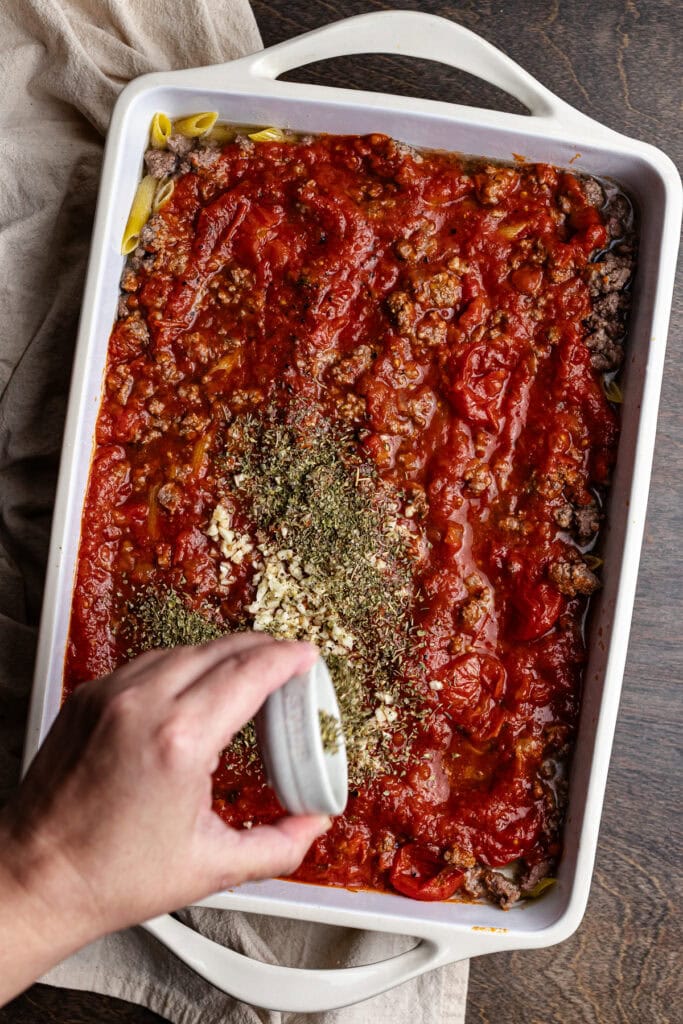 Rich, homemade baked ziti casserole with marinara, ground beef, and melted cheese in a white baking dish. Perfect for family dinners and comfort food cravings.