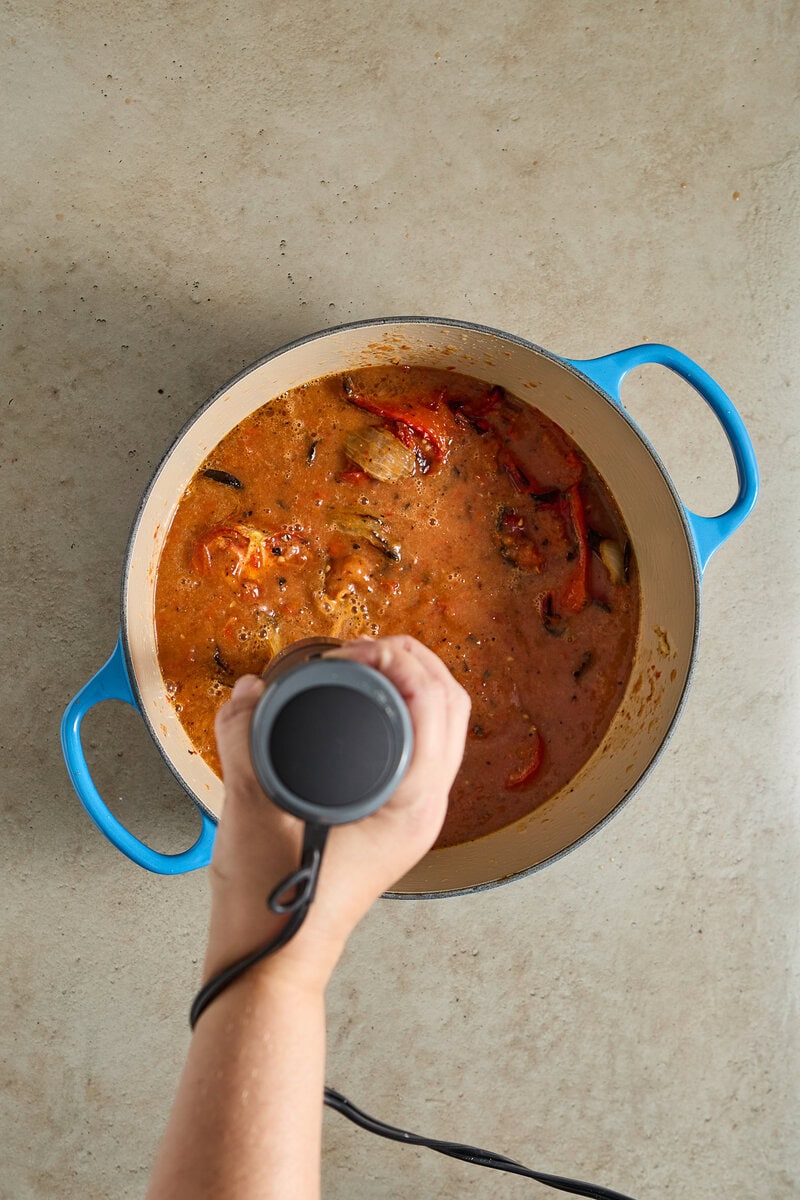 Spicy homemade stew being prepared in a blue pot for delicious comfort food.