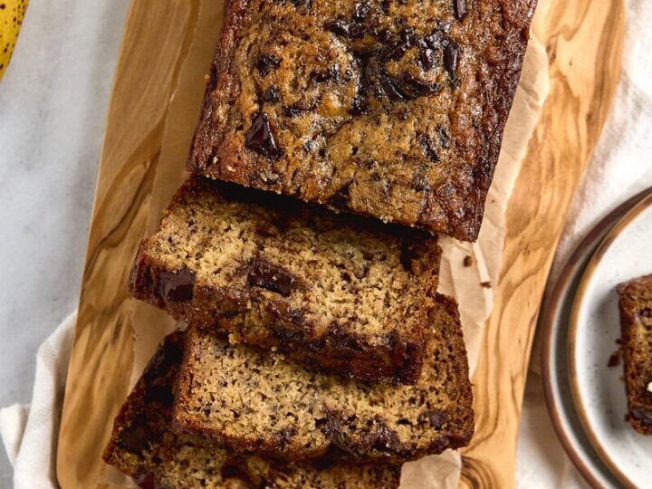 Brown Butter Chocolate Chunk Banana Bread on a wood cutting board sliced.