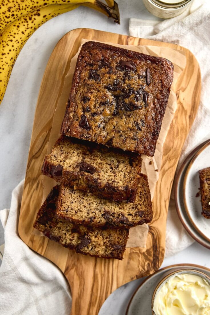 Brown Butter Chocolate Chunk Banana Bread on a wood cutting board sliced.