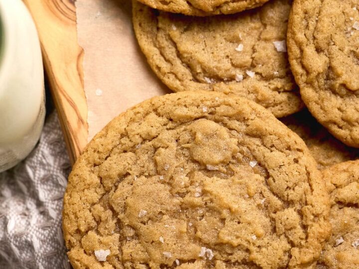 Soft, freshly baked chocolate chipless cookies with a golden brown color, sprinkled with sea salt, perfect for snacking or dessert.
