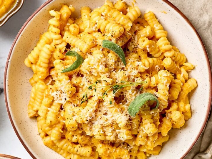 Creamy butternut squash pasta sauce with sage and Parmesan cheese, served in a rustic bowl, perfect for cozy fall meals and vegetarian dinner recipes.