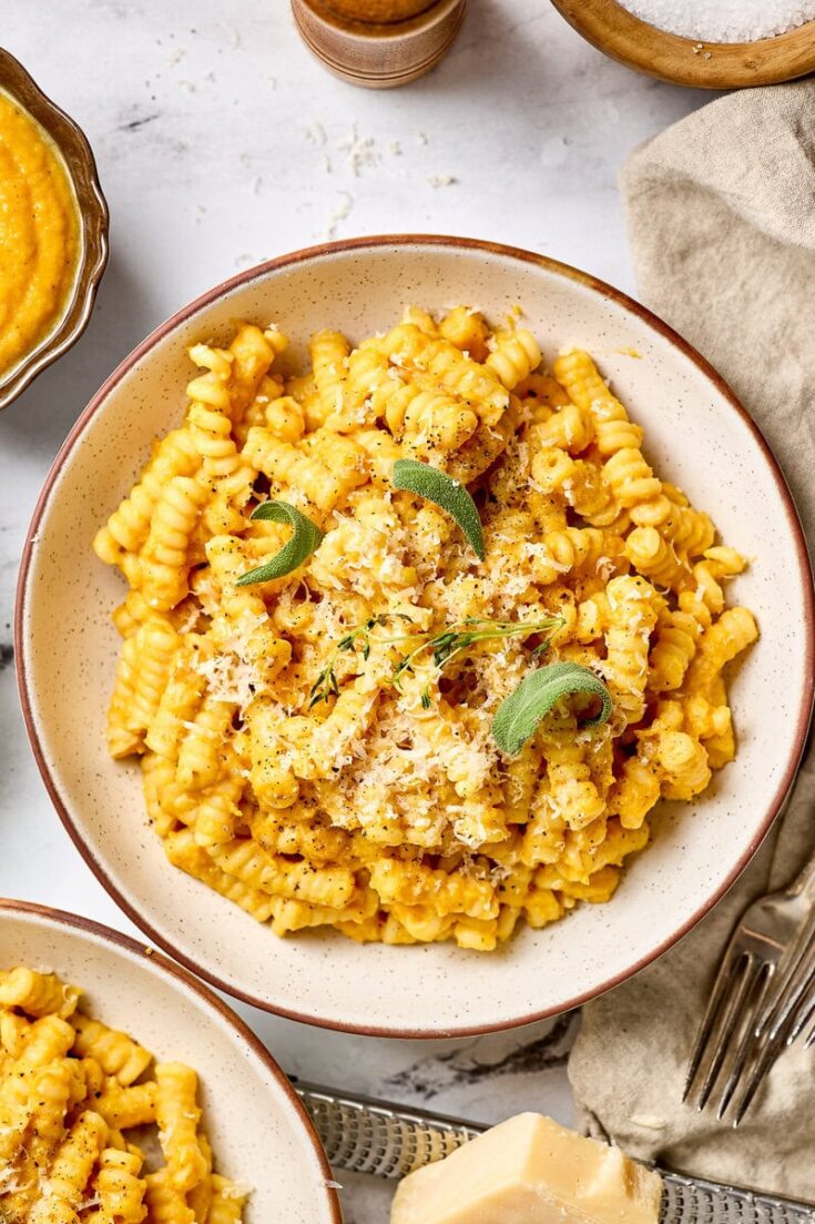 Creamy butternut squash pasta sauce with sage and Parmesan cheese, served in a rustic bowl, perfect for cozy fall meals and vegetarian dinner recipes.
