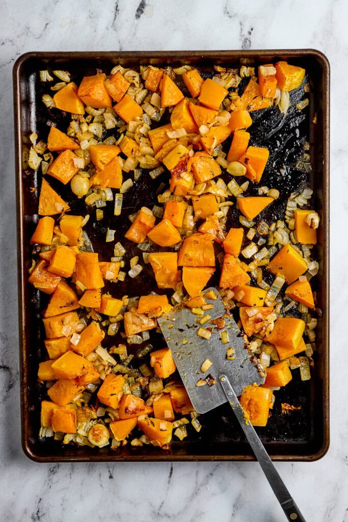 Sweet roasted butternut squash and caramelized onions on a baking sheet.