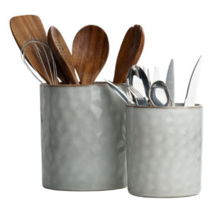 Wooden and metal kitchen utensils in ceramic containers for cooking and baking supplies.