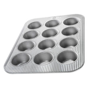 Sweater mold in a non-stick, aluminum muffin pan for baking chocolates, candies, or small desserts, perfect for homemade treats and confectionery projects.