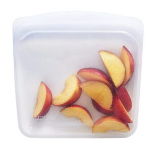 Sliced fresh peaches on a white storage container, perfect for peach desserts or snacks.