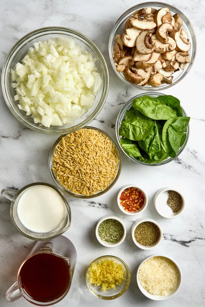Chopped onions, sliced mushrooms, fresh spinach leaves, Israeli couscous, milk, lemon zest, grated Parmesan cheese, red pepper flakes, dried oregano, dried thyme, black pepper, and cream.