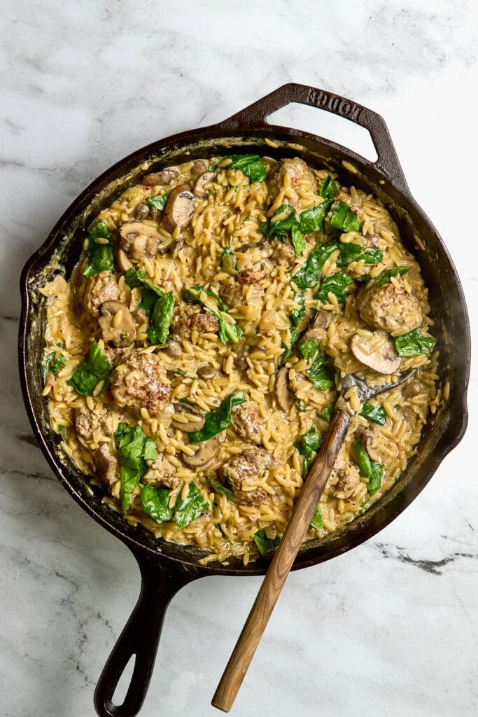 Creamy mushroom and chicken skillet pasta with spinach in cast iron skillet, savory and comforting dinner idea, perfect for cozy nights and family meals.