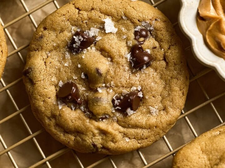 Chewy peanut butter chocolate chip cookies with sea salt on cooling rack, homemade baked treats from Stuck On Sweet bakery, perfect for dessert or snack.