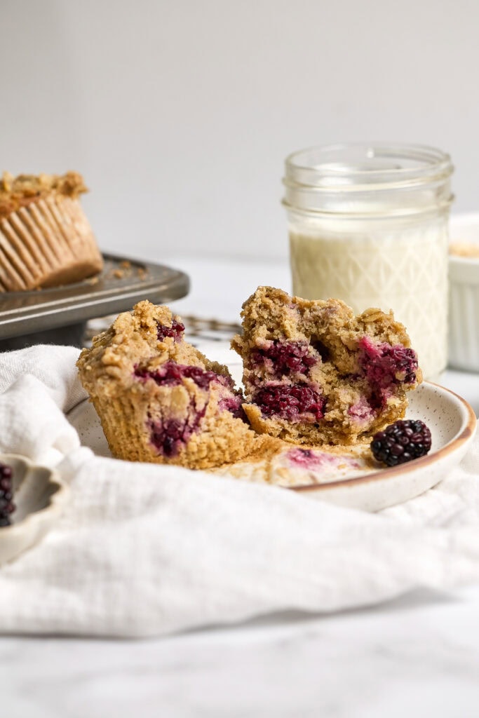 Delicious blackberry oatmeal muffin with fresh blackberries, perfect for breakfast or snack. Moist, flavorful, topped with crumble, served with cream and blackberries on the side.