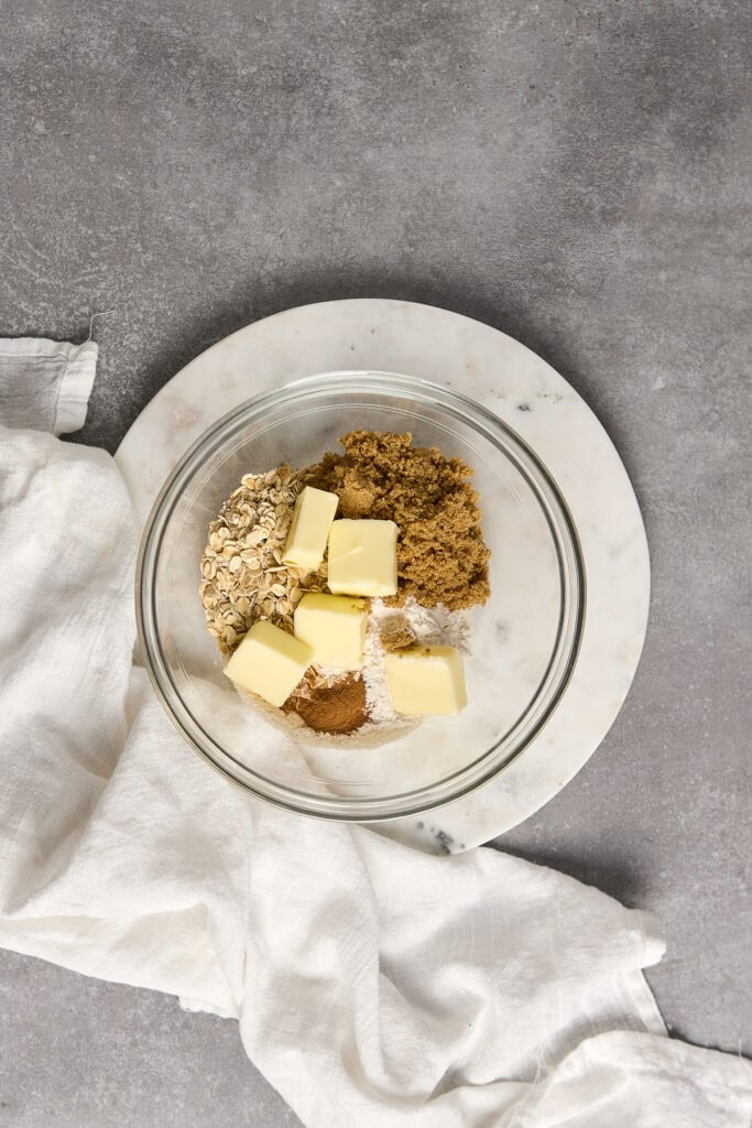 Add a delightful shot of cookie dough ingredients including butter, oats, sugar, and spices in a glass bowl for homemade cookies.