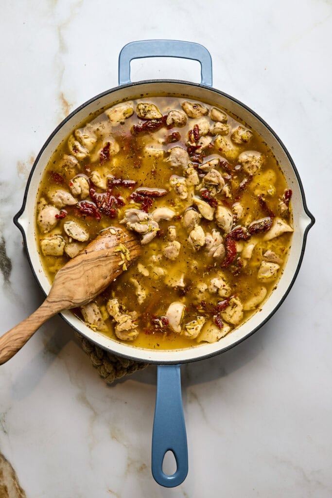 Delicious homemade chicken gnocchi soup in a skillet with herbs, chicken, sun-dried tomatoes, and a savory broth. Perfect comfort food for chilly days, easy to make from scratch.