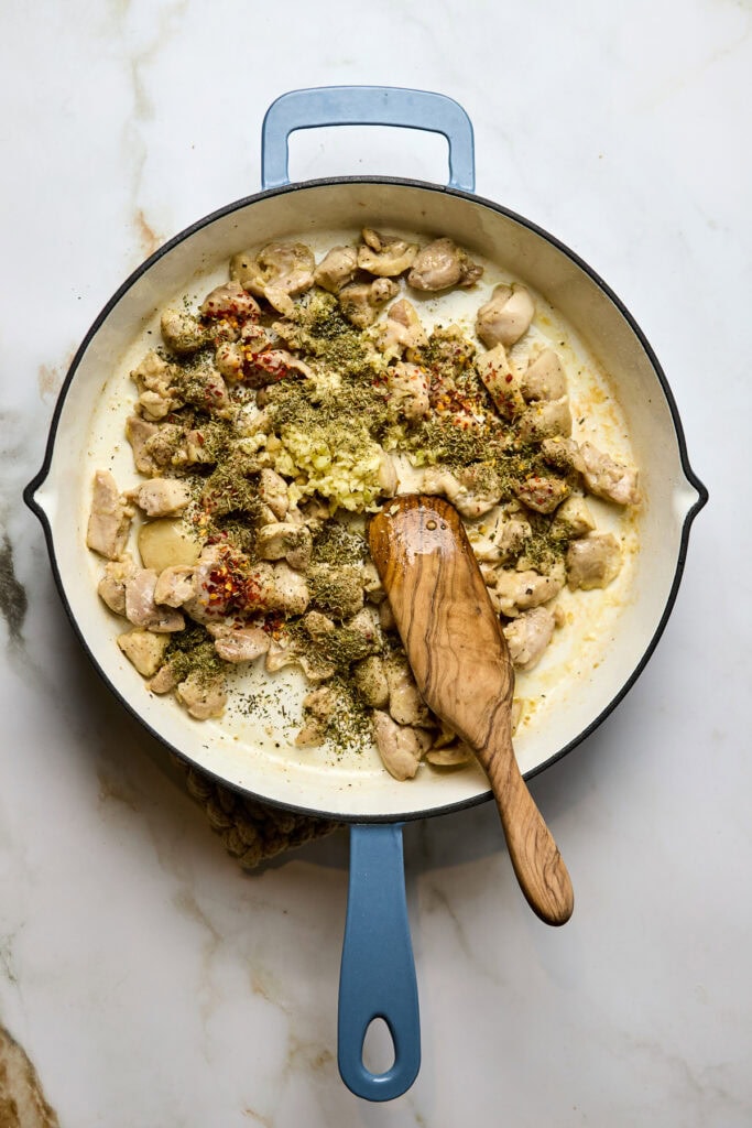 Delicious chicken recipe cooking in a skillet with herbs, garlic, and spices for a flavorful dish. Perfect for easy weeknight dinners or meal prep.