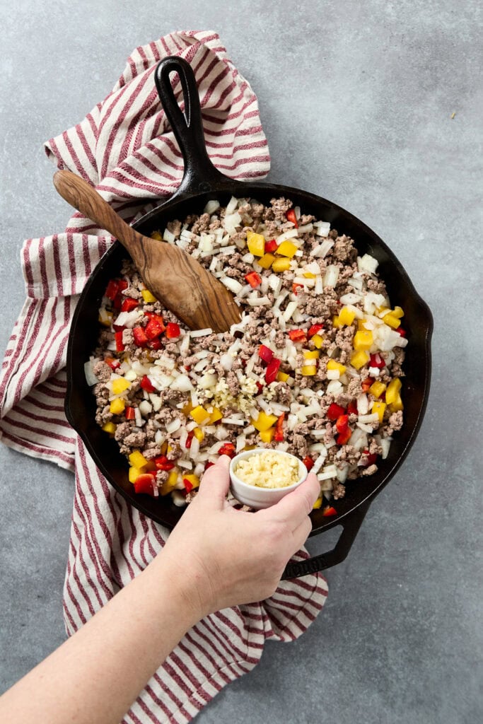 Delicious beef skillet with colorful vegetables, onions, and melted cheese, perfect for a quick and hearty meal.