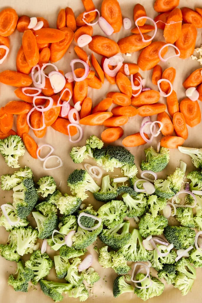 Colorful chopped carrots, broccoli florets, and sliced onions ready for cooking or salad preparation.