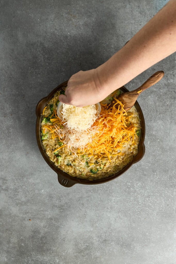 Delicious cheesy chicken and rice casserole with shredded cheese, fresh herbs, and a creamy sauce, perfect for a comforting family meal.