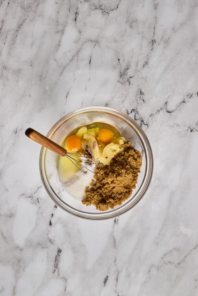 Mixing bowl with eggs, brown sugar, and oats for soft and chewy brown butter oatmeal cookies. Perfect for baking delicious homemade cookies.