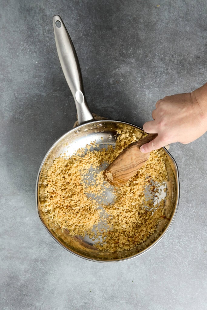 Delicious chicken parmesan being prepared in a skillet with golden breadcrumbs and melted cheese, perfect for a comforting family dinner.