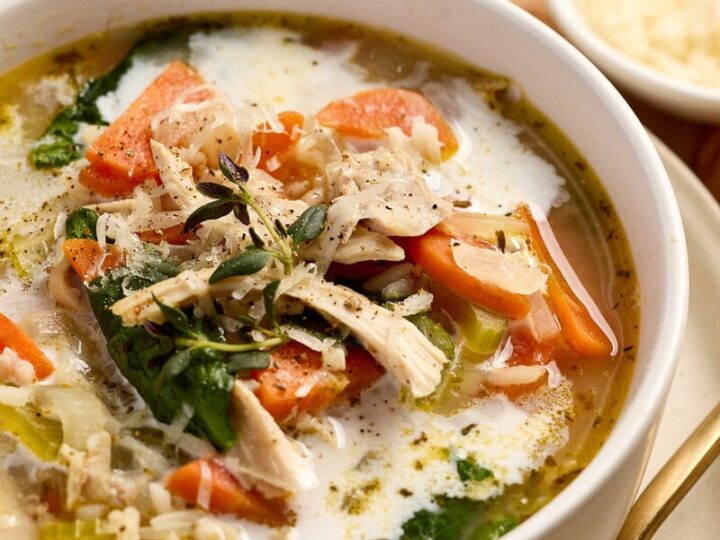 Delicious lemon chicken rice soup with shredded chicken, vegetables, and herbs in a creamy broth, perfect for comforting meals.