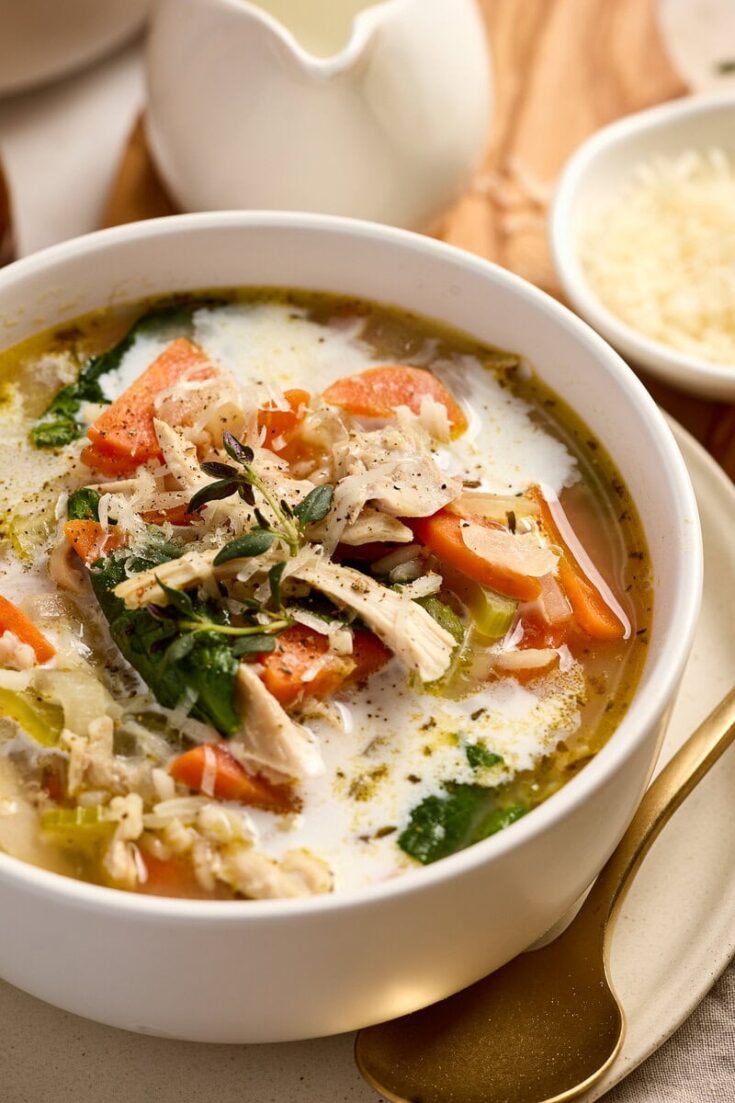 Delicious lemon chicken rice soup with shredded chicken, vegetables, and herbs in a creamy broth, perfect for comforting meals.