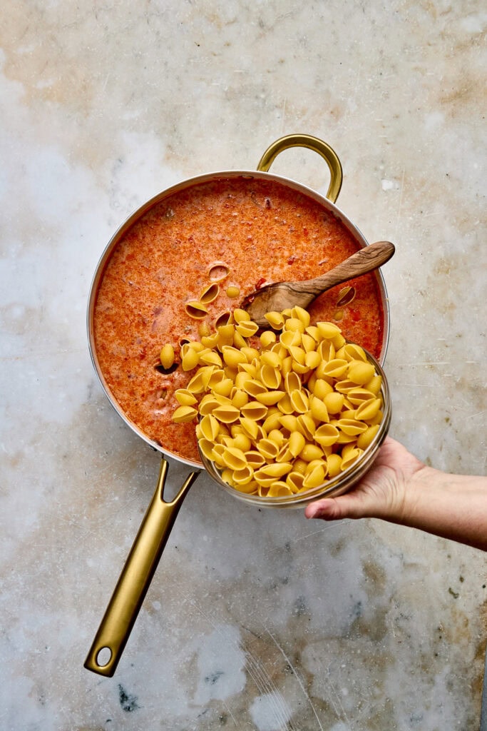 Creamy taco pasta with  in a golden pot, served with a wooden spoon, perfect for comfort food lovers and pasta enthusiasts.