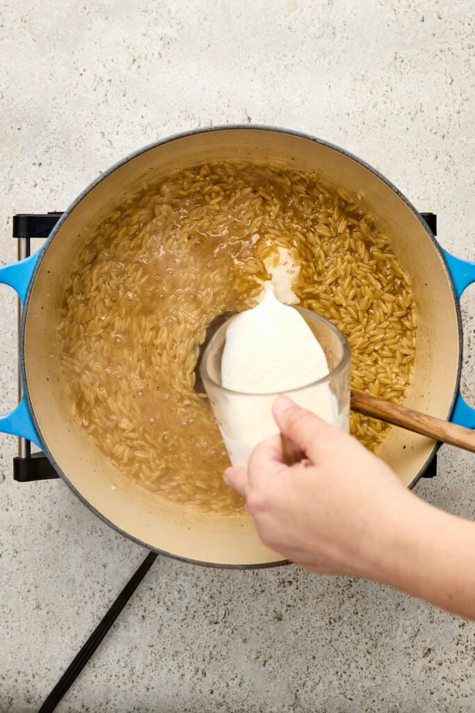 Delicious homemade rice pudding being prepared on the stove, with milk added to the simmering rice. Perfect for dessert lovers seeking comfort food recipes.