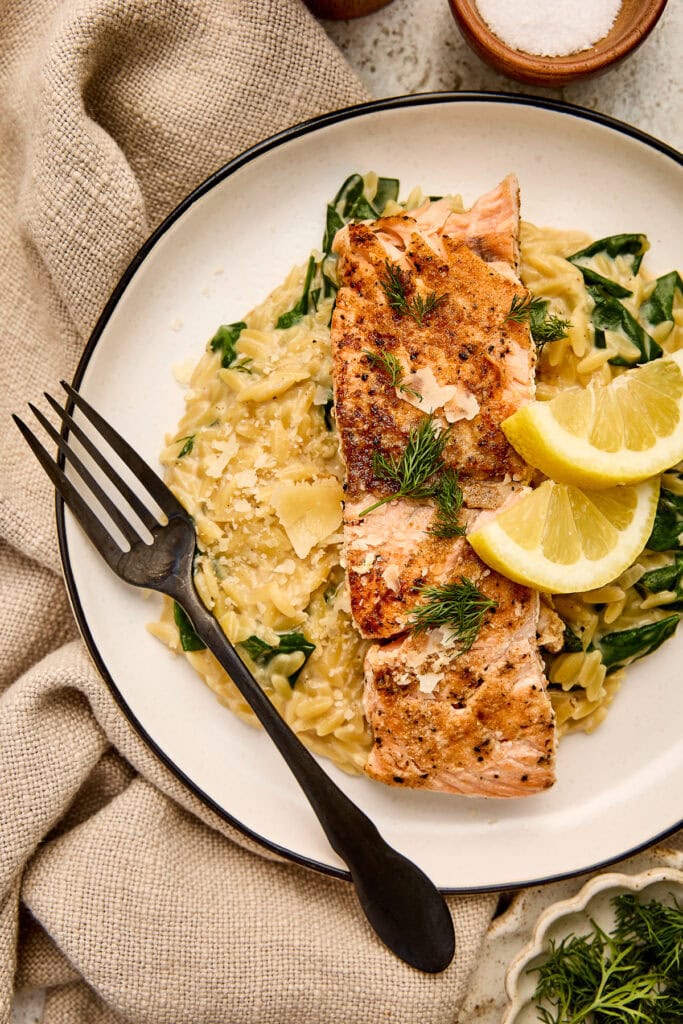 Delicious seared salmon served over creamy orzo with fresh dill and lemon wedges, perfect for a healthy and flavorful meal.