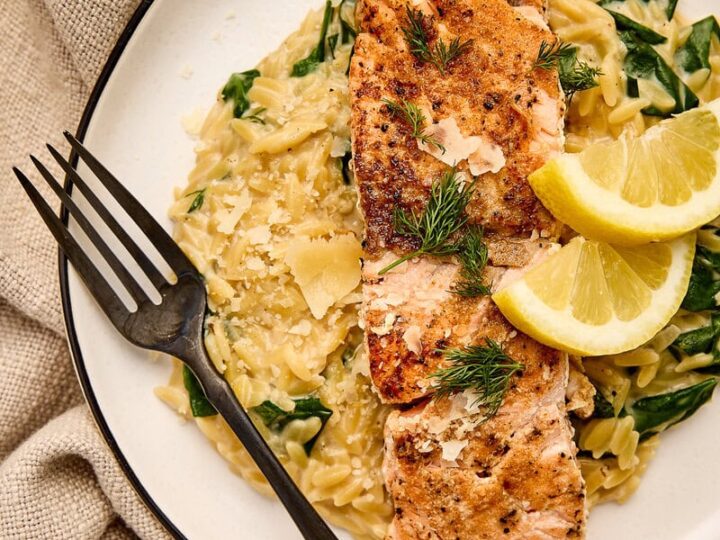 Delicious seared salmon served over creamy orzo with fresh dill and lemon wedges, perfect for a healthy and flavorful meal.