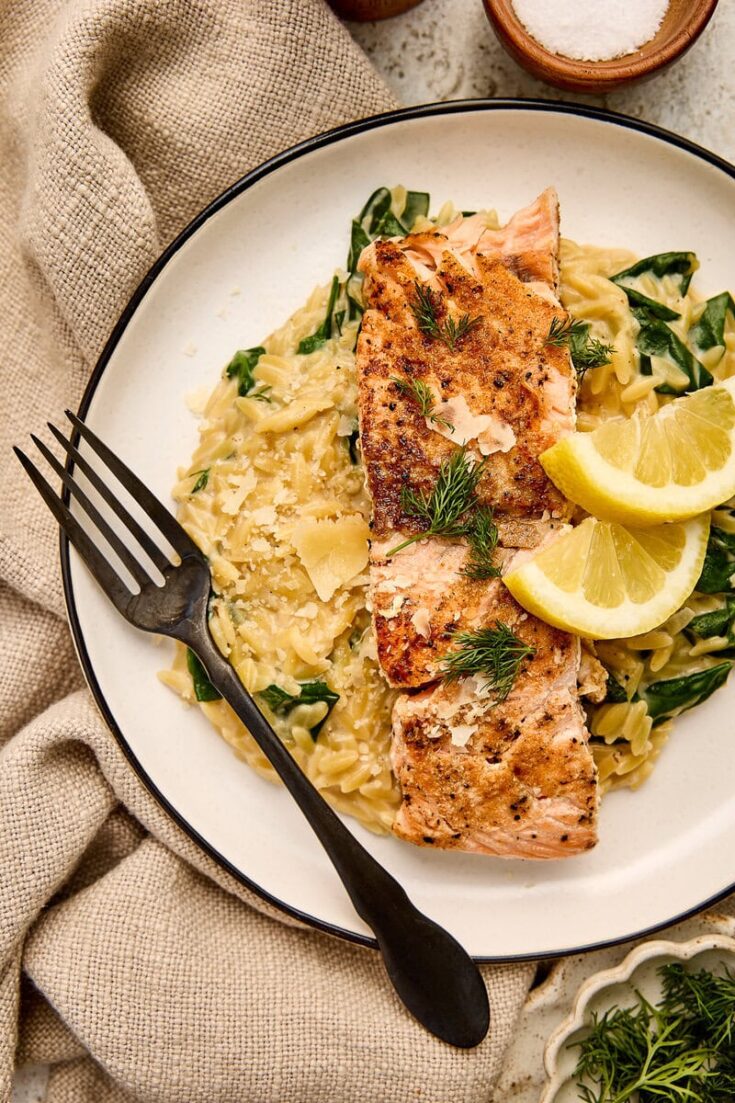 Delicious seared salmon served over creamy orzo with fresh dill and lemon wedges, perfect for a healthy and flavorful meal.
