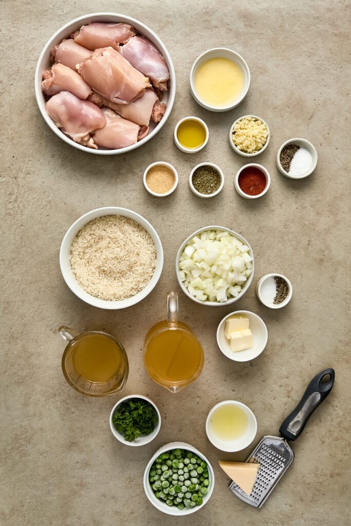 Preparation of chicken and vegetables for cooking, including chicken thighs, onions, garlic, herbs, and spices on a kitchen countertop.