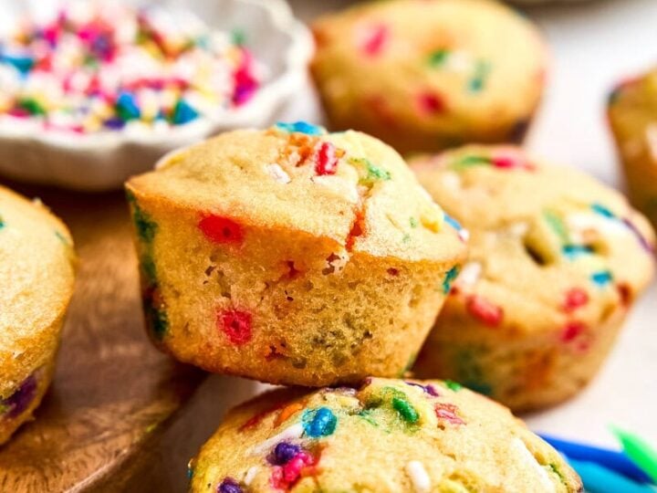 Close-up of freshly baked mini muffins with colorful sprinkles on top, perfect for celebrations and parties.
