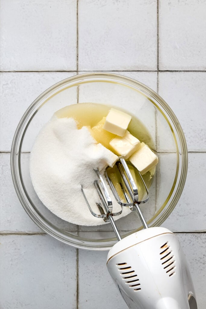Mixing butter, sugar, and vanilla in a glass bowl for baking at Stuck On Sweet.