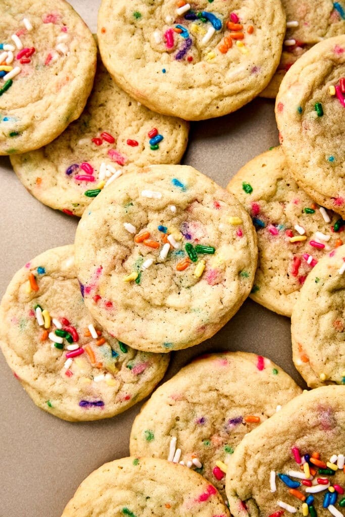 Close-up of soft, chewy funfetti cookies with colorful sprinkles on a neutral background.