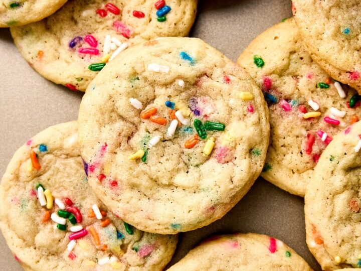Close-up of soft, chewy funfetti cookies with colorful sprinkles on a neutral background.